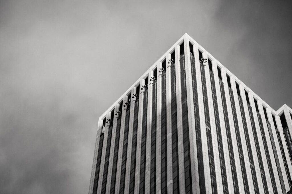 pexels-photo-7078175 Black and white photo of a modern skyscraper with geometric design and low angle view.